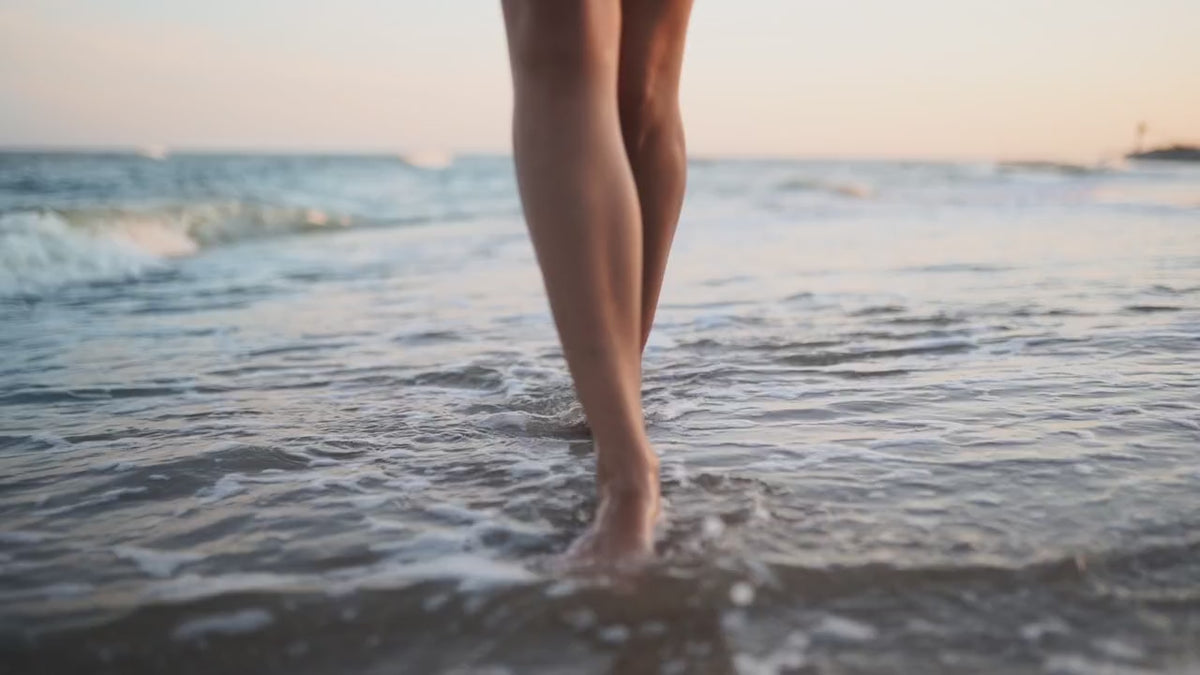 Carica video: Donna cammina sulla spiaggia